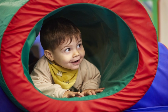 Toddler smiling in play tunnel