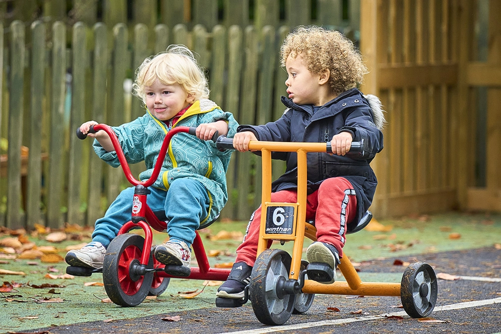 2 children riding trikes