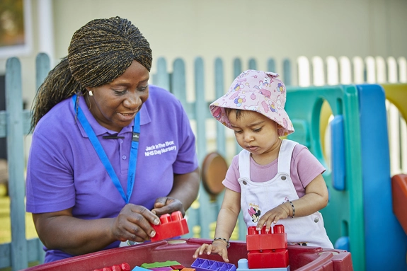 Nursery Staff with Toddler playing with Blocks